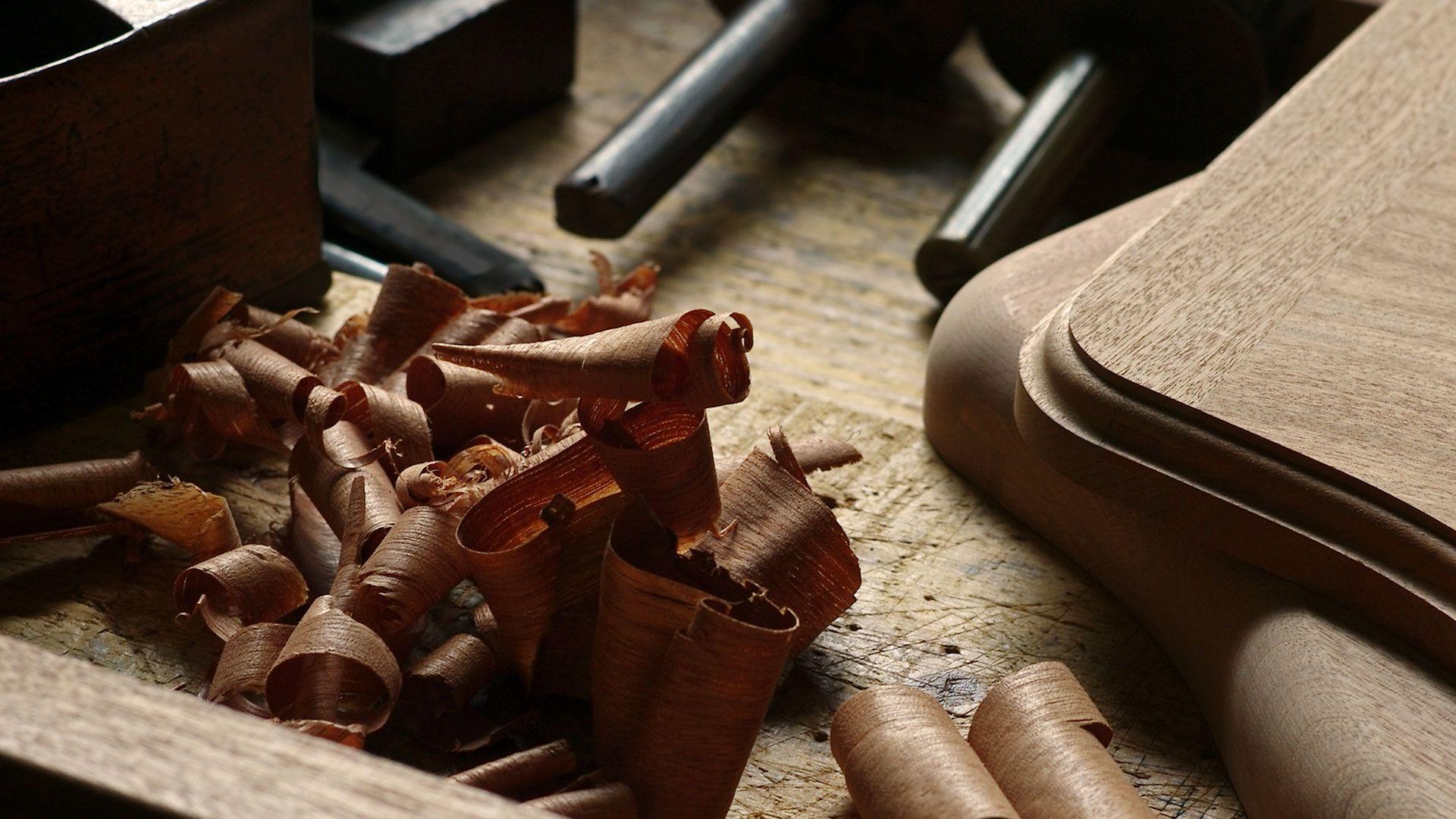 Wood shavings beside a rounded wooden board